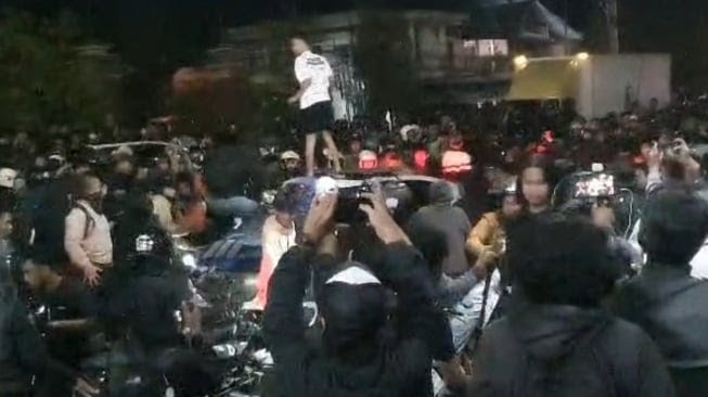 Sebuah mobil polisi yang melintas di Jalan Ring Road depan Polda DIY menjadi sasaran amukmassa. (Joke)