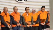 Wamenaker Immanuel Ebenezer bersama tersangka lain dengan rompi oranye dan tangan terborgol. (Joke)
