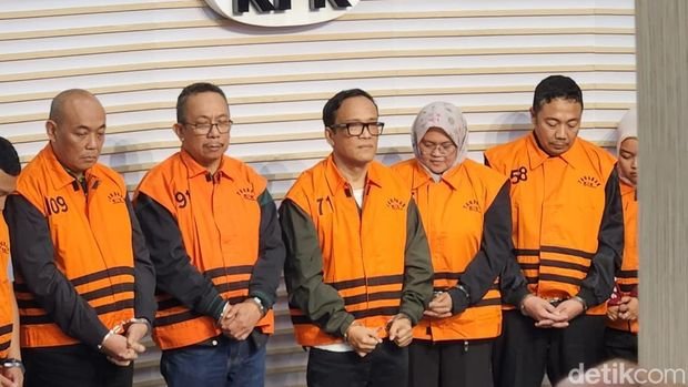 Wamenaker Immanuel Ebenezer bersama tersangka lain dengan rompi oranye dan tangan terborgol. (Joke)