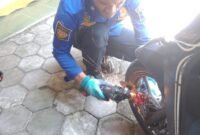 Petugas Damkar Jogja melepas kunci cakram motor yang macet dengan gerinda. (Joke)