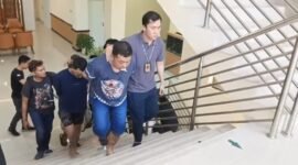 Tersangka pelaku pencurian uang Rp10 miliar, A, bersama dua tersangka lainnya digiring petugas masuk Mapolresta Solo. (Dok Polresta Solo)