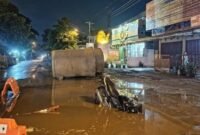 Penampakan di video viral, seorang pengendara sepeda motor berpelat merah terperosok ke dalam lubang galian proyek saluran air yang tertutup genangan air di Jalan Kebun Raya, Rejowinangun, Kotagede, Senin (20/10/2025) malam. (Joke)