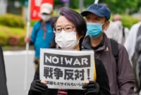 Para pengunjuk rasa berbaris di jalan-jalan pusat kota Tokyo, Jepang, pada 15 Mei 2022, menandai peringatan 50 tahun pengembalian Okinawa ke Jepang dari kendali Amerika Serikat. (Xinhua/Christopher Jue)