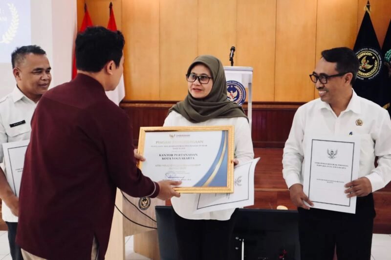 Kepala Perwakilan Ombudsman RI DIY Muflihul Hadi menyerahkan penghargaan kepada Kepala Kantor Pertanahan Kota Yogyakarta Sri Martini di Aula Kantor Wilayah Direktorat Jenderal Pemasyarakatan DIY, Selasa (10/2/2026). (Humas Pemkot)