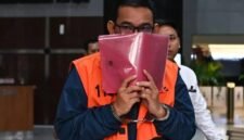 Tersangka kasus dugaan suap importasi di Direktorat Jenderal Bea dan Cukai Orlando Hamonangan menutupi wajahnya usai menjalani pemeriksaan di Gedung Merah Putih KPK, Jakarta, Senin (27/4/2026). (Indrianto Eko Suwarso/Antara Foto)