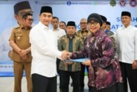 Wakil Gubernur Dimyati (kiri) bersalaman dengan perwakilan penerima saat menyerahkan berkas dokumen dalam acara penyerahan 5.000 Sertifikat Halal UMKM