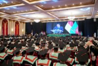 Kepala Badan Ekonomi Kreatif menyampaikan orasi ilmiah yang ditayangkan melalui layar besar di hadapan ratusan wisudawan