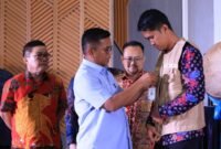 Gubernur Andra Soni Menyematkan Tanda Pengenal Ke Perwakilan Petugas Payment Point 