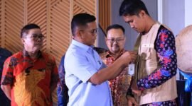 Gubernur Andra Soni Menyematkan Tanda Pengenal Ke Perwakilan Petugas Payment Point 