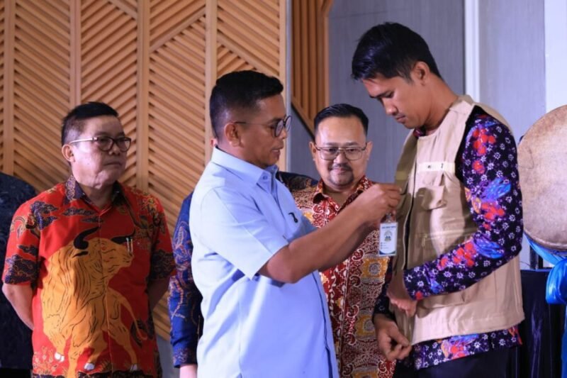Gubernur Andra Soni Menyematkan Tanda Pengenal Ke Perwakilan Petugas Payment Point 