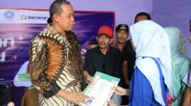 Tri Adhianto secara simbolis menyerahkan dokumen berkas kepada warga penerima manfaat saat meresmikan hasil pembangunan program Bantuan Rumah Tidak Layak Huni di Kecamatan Pondok Gede