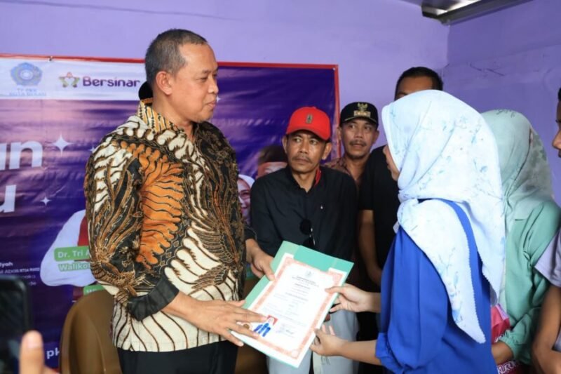 Tri Adhianto secara simbolis menyerahkan dokumen berkas kepada warga penerima manfaat saat meresmikan hasil pembangunan program Bantuan Rumah Tidak Layak Huni di Kecamatan Pondok Gede