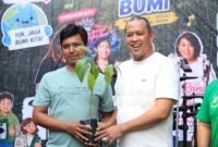 Wali Kota Bekasi menyerahkan bibit pohon secara simbolis kepada warga di kawasan Hutan Kota Bekasi