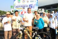 Wali Kota Bekasi berfoto bersama para relawan sosial di dekat sepeda doorprize di Plaza Patriot Candrabhaga
