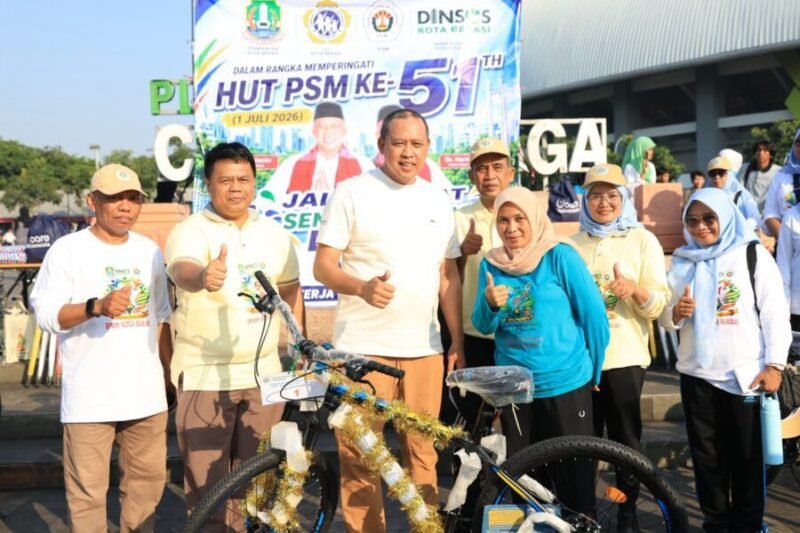 Wali Kota Bekasi berfoto bersama para relawan sosial di dekat sepeda doorprize di Plaza Patriot Candrabhaga
