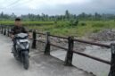 Seorang warga melintasi jembatan darurat di Nagari Anduriang, Kecamatan 2x11 Kayu Tanam, Kabupaten Padang Pariaman, Sumatera Barat