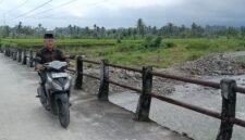 Seorang warga melintasi jembatan darurat di Nagari Anduriang, Kecamatan 2x11 Kayu Tanam, Kabupaten Padang Pariaman, Sumatera Barat
