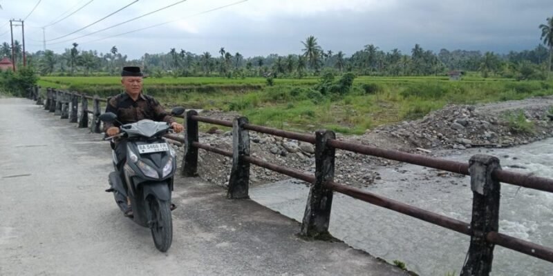 Seorang warga melintasi jembatan darurat di Nagari Anduriang, Kecamatan 2x11 Kayu Tanam, Kabupaten Padang Pariaman, Sumatera Barat