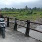 Seorang warga melintasi jembatan darurat di Nagari Anduriang, Kecamatan 2x11 Kayu Tanam, Kabupaten Padang Pariaman, Sumatera Barat