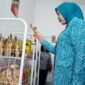 Ketua TP PKK Provinsi Sumatera Selatan melihat dan memilih produk makanan kemasan hasil karya kader PKK saat meresmikan Warung PKK Kota Lubuk Linggau