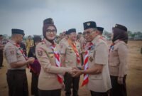 Wakil Gubernur Jihan Nurlela dan pejabat lain berjabat tangan dengan seorang tokoh pramuka