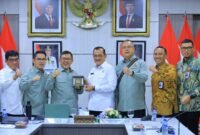 Sekda Provinsi Sumatera Selatan Edward Candra menerima cendera mata dari Ketua Tim Badan Aspirasi Masyarakat (BAM) DPR RI dalam pertemuan terkait hubungan industrial di Ruang Rapat Bina Praja, Palembang, Rabu (23/9/2026).
