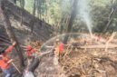 Petugas gabungan melakukan penyemprotan dan pendinginan lahan bekas kebakaran di Bukit Bluwuk, Kaliwiro, Wonosobo