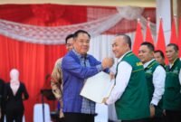 H. Herman Deru secara simbolis menyerahkan dokumen kepada Ketua Umum terpilih, Apriyadi, saat mengukuhkan Pengurus Ikatan Keluarga Musi Banyuasin (IKA-Muba) periode 2026–2030 di Griya Agung