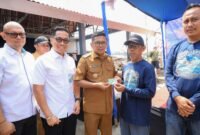 Andra Soni secara simbolis menyerahkan Kartu Kusuka/Asuransi Nelayan kepada warga dalam kunjungan kerja di Kecamatan Panimbang, Pandeglang