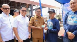 Andra Soni secara simbolis menyerahkan Kartu Kusuka/Asuransi Nelayan kepada warga dalam kunjungan kerja di Kecamatan Panimbang, Pandeglang