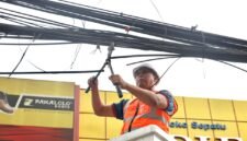 Tri Adhianto memotong jaringan kabel udara fiber optik yang semrawut di salah satu ruas jalan utama Kota Bekasi