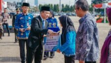 Marindo Kurniawan menyerahkan secara simbolis tali asih bagi anggota KORPRI purna bhakti saat Upacara Peringatan Hari Kesaktian Pancasila Tahun 2026 di Lapangan Korpri